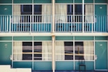 black armless chair outside blue concrete house