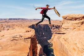 man jumping on rock formation