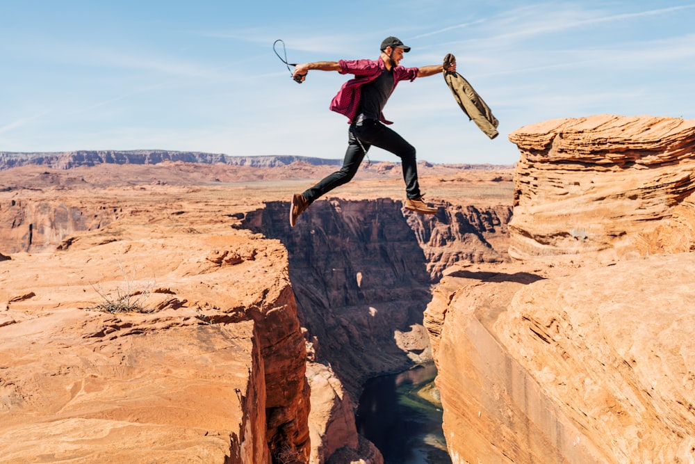 man jumping on rock formation