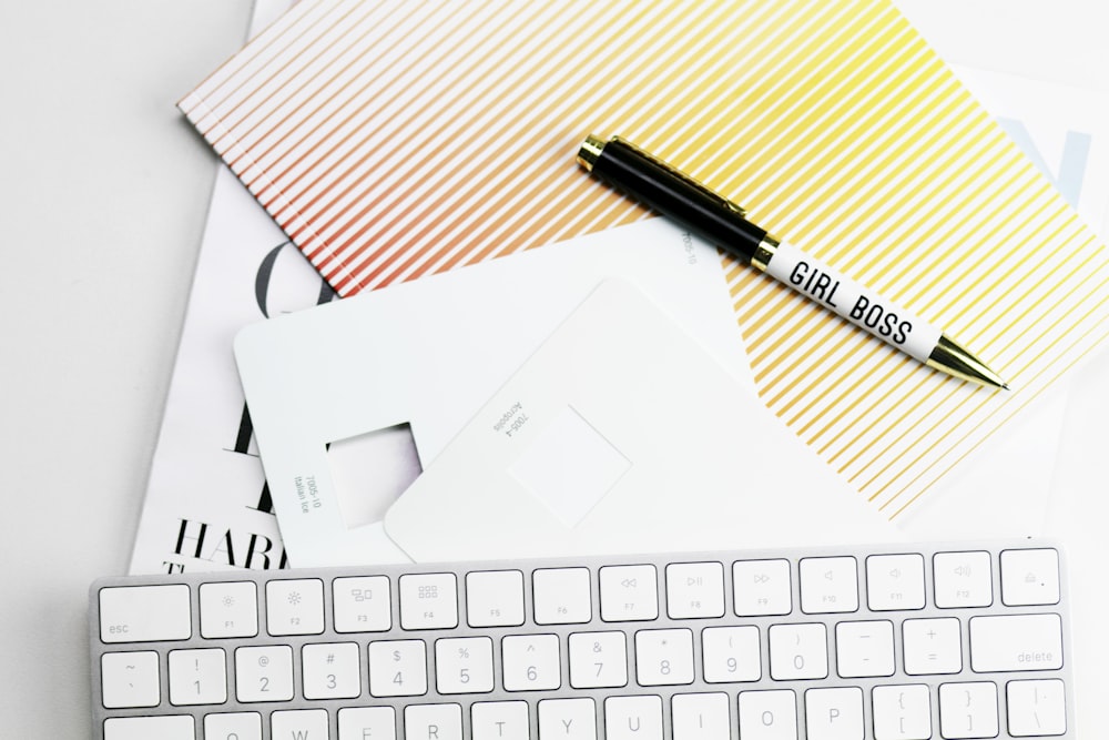 Apple Magic Keyboard, Papiere und Stift auf weißer Oberfläche