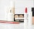 An elegant arrangement of cosmetics on a soft fabric backdrop.