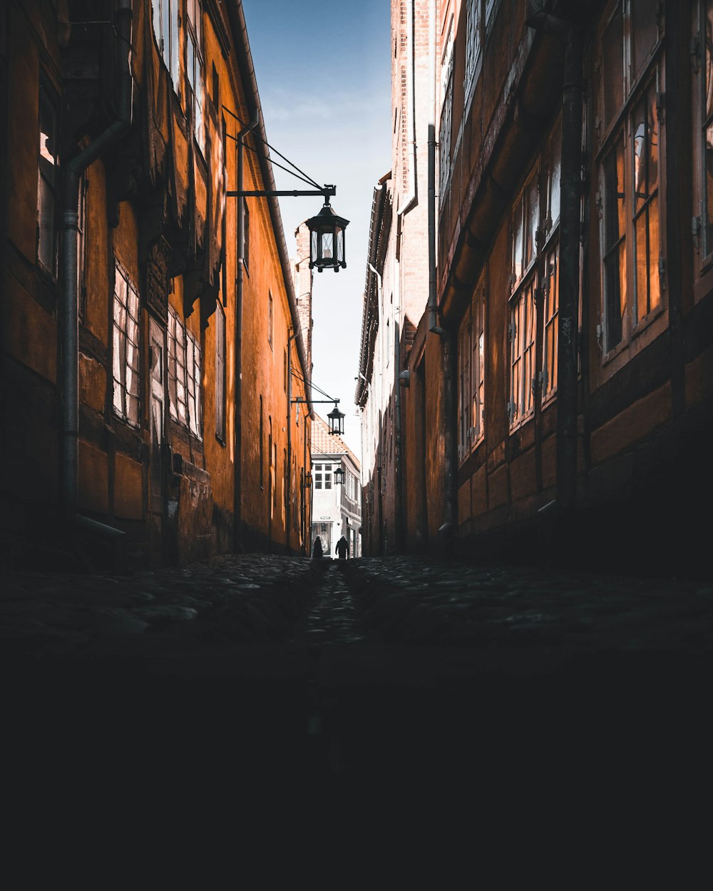 two people walking on hallway between building