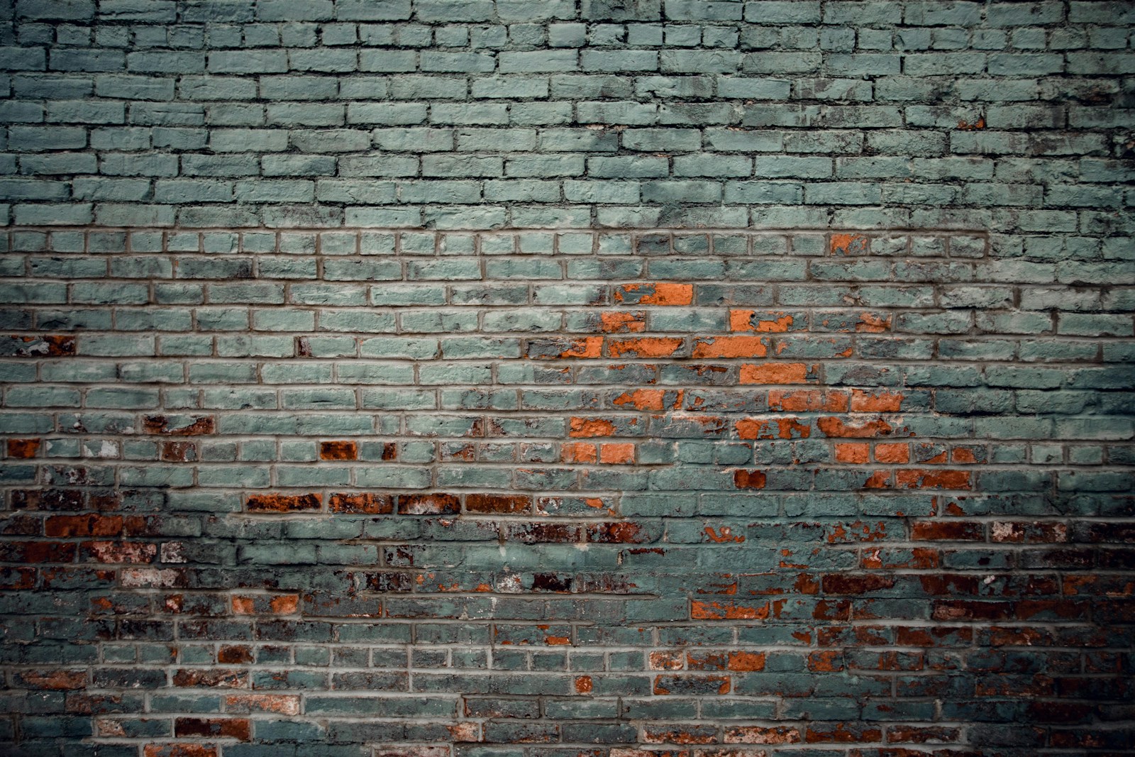 Before: weathered brick wall with peeling grey paint and failed mortar