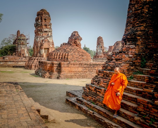 monk walking on brown stair in Wat Phra Mahatat Thailand