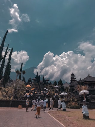 A serene group of pilgrims walking together towards a temple nestled in the Himalayan foothills during sunrise.