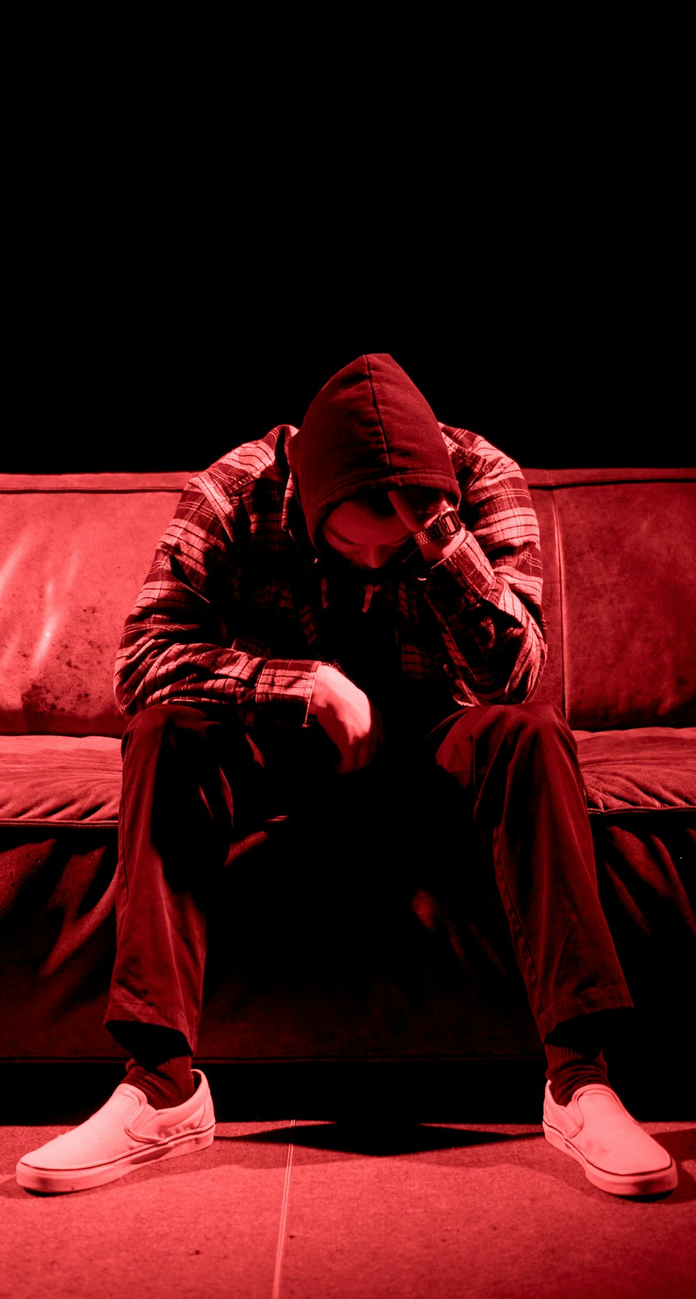 man wearing grey hooded jacket sitting on the sofa photography