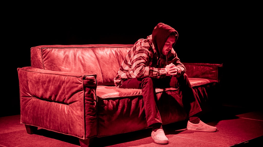 man sitting on leather sofa