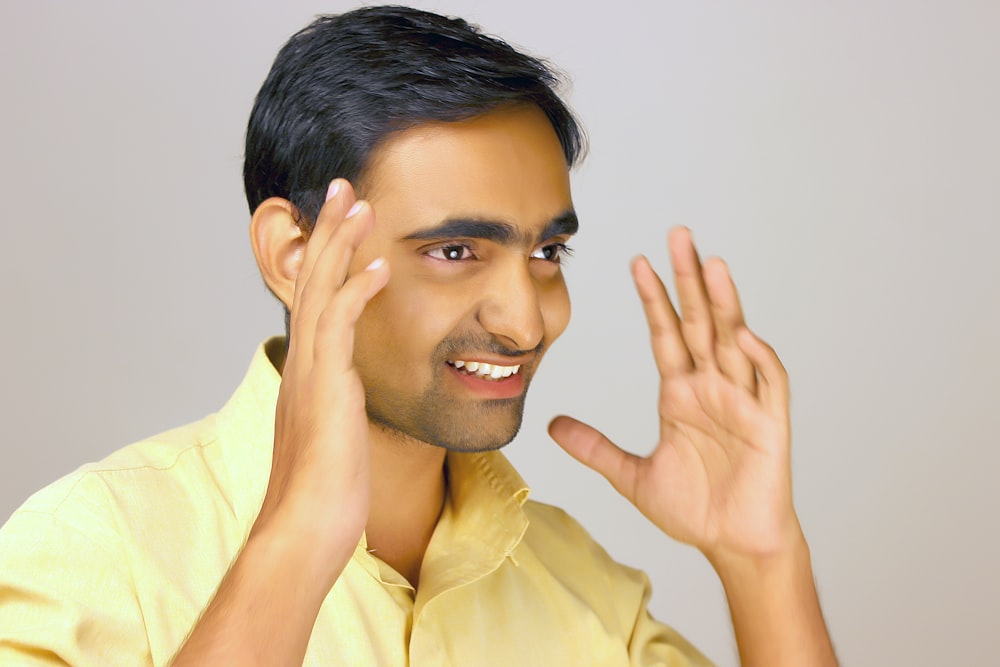 a man is smiling and making a hand gesture
