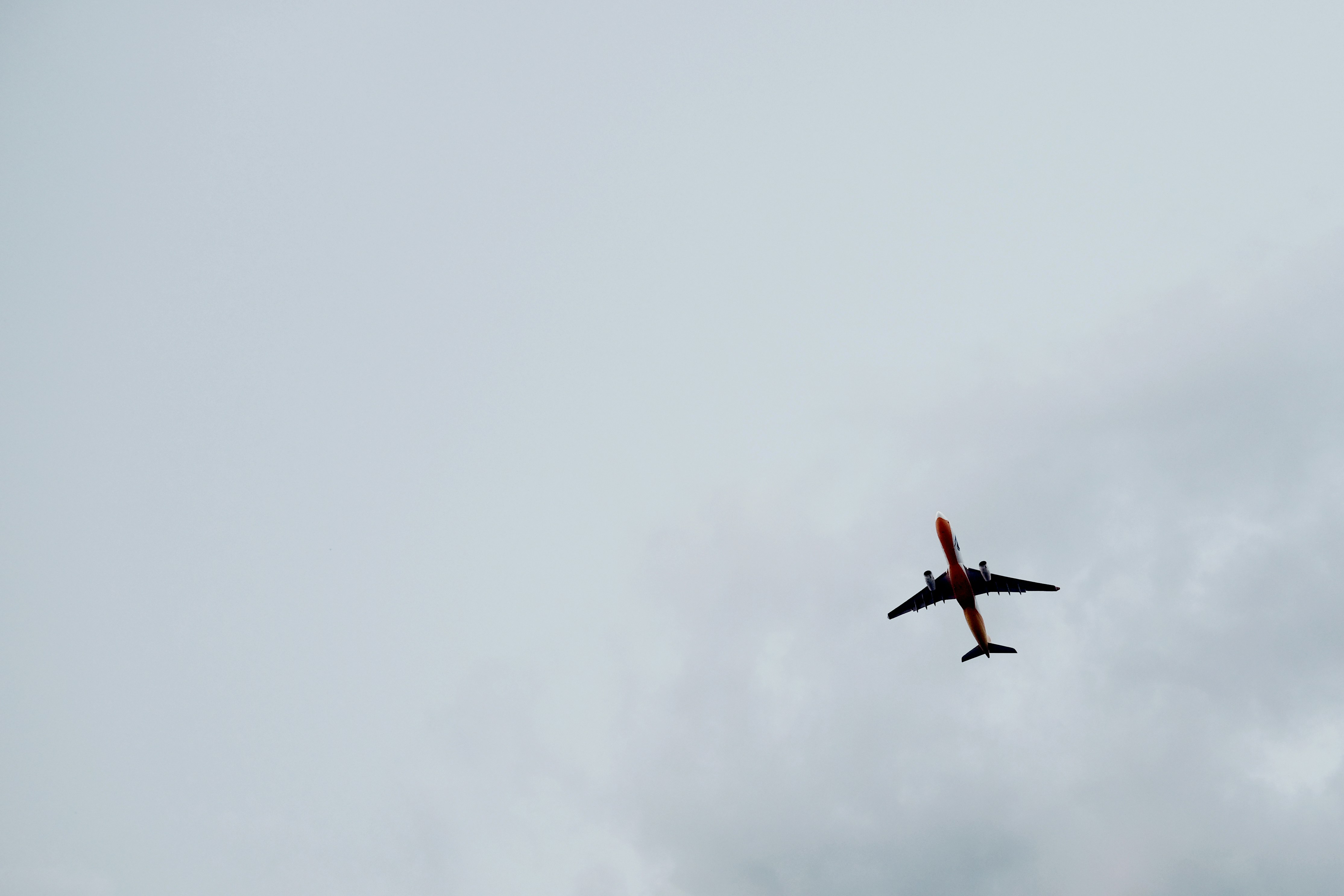 low angle photography of plane flight under cloudy sky, 