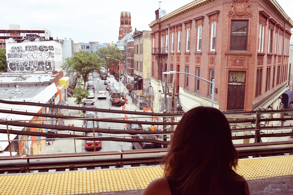 woman in black tank top sitting on brown wooden bench during daytime