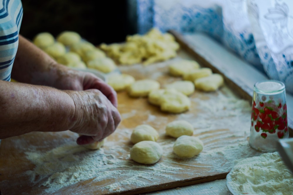 person making dough on brown wooden board