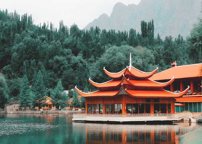 orange wooden building near green trees at daytime