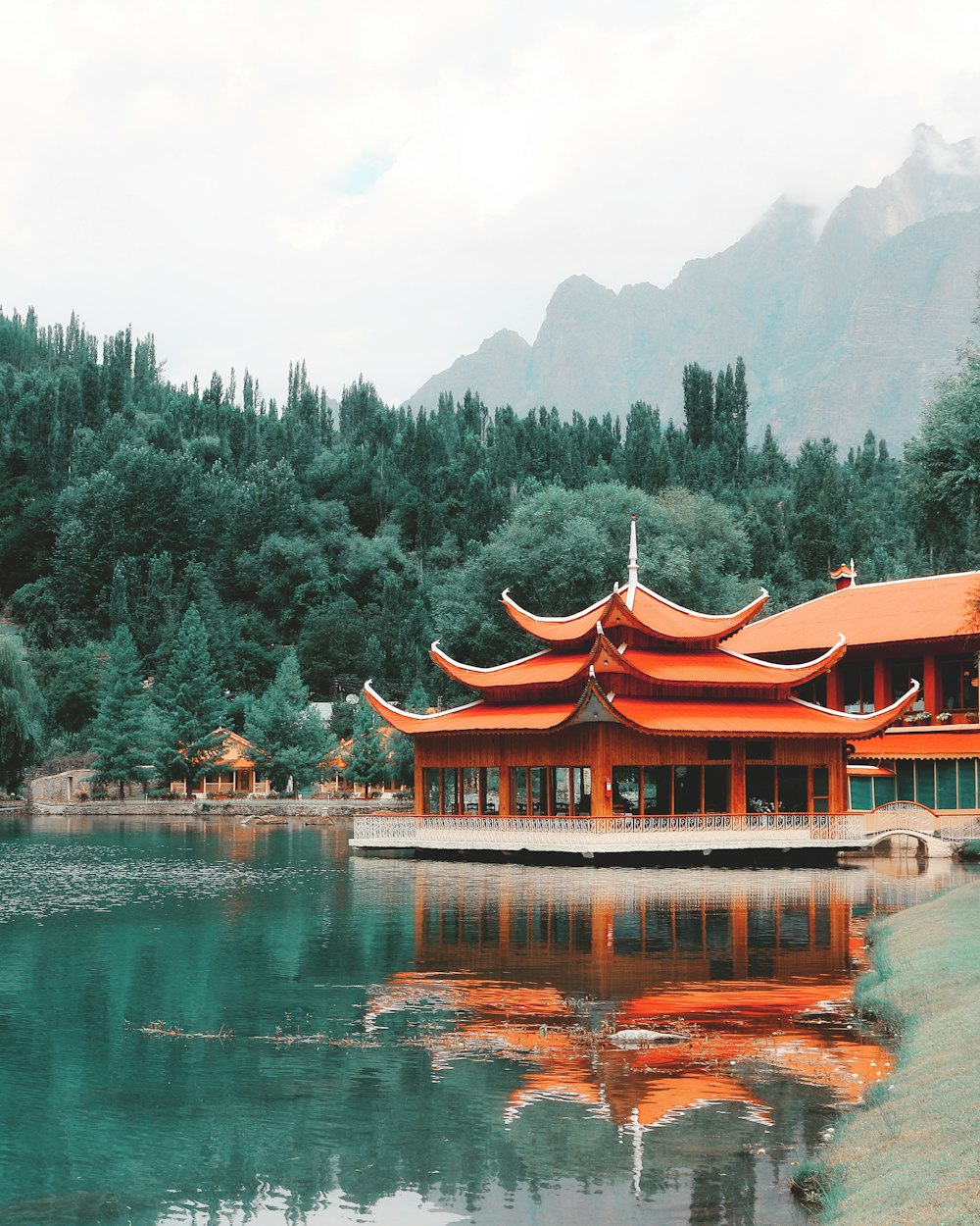 orange wooden building near green trees at daytime