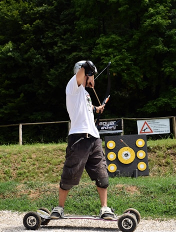 A rider practicing archery on horseback in a lush green field.