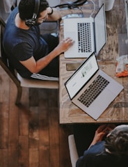 man sitting on chair and looking laptop computer