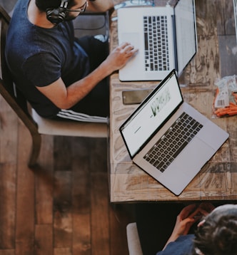 man sitting on chair and looking laptop computer