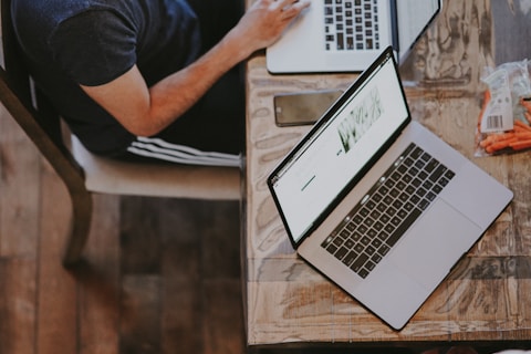 man sitting on chair and looking laptop computer