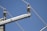 A section of an electrical power line covered in ice and snow against a clear blue sky. The cables and insulators are thickly layered with ice, indicating cold weather conditions.