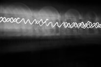 A monochrome photo of a glowing white line cutting through a dark void.