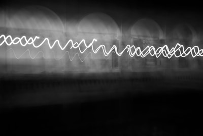 A monochrome photo of a glowing white line cutting through a dark void.