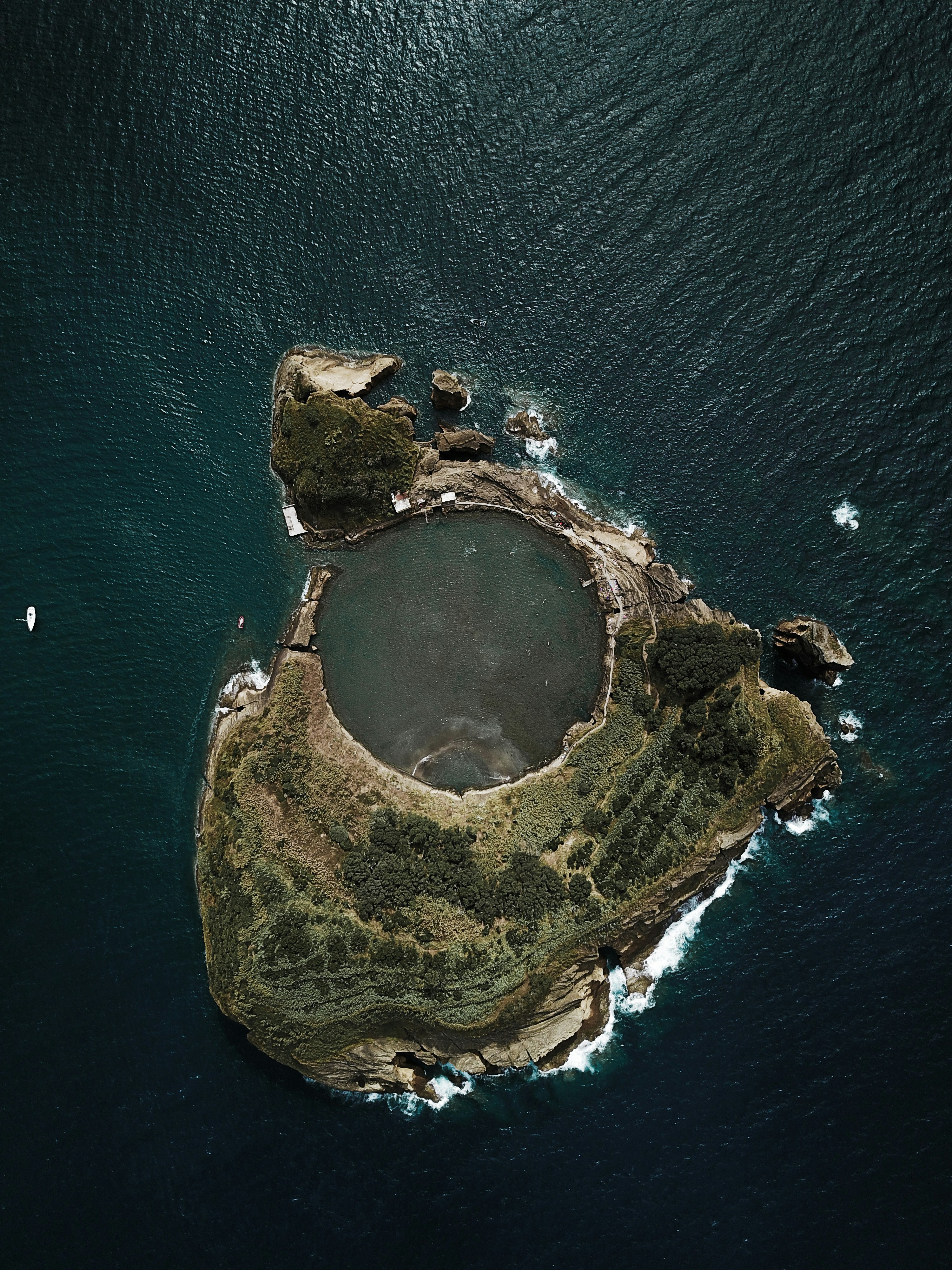 top view photography of island covered with trees surrounded by body of water during daytime