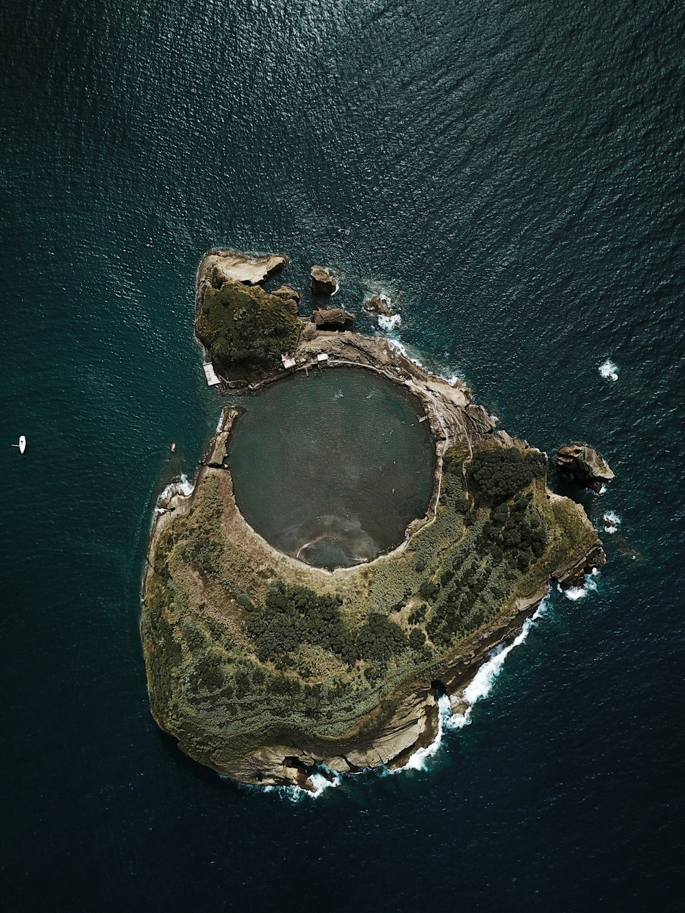 Photographie de vue de dessus d’une île couverte d’arbres entourée d’un plan d’eau pendant la journée