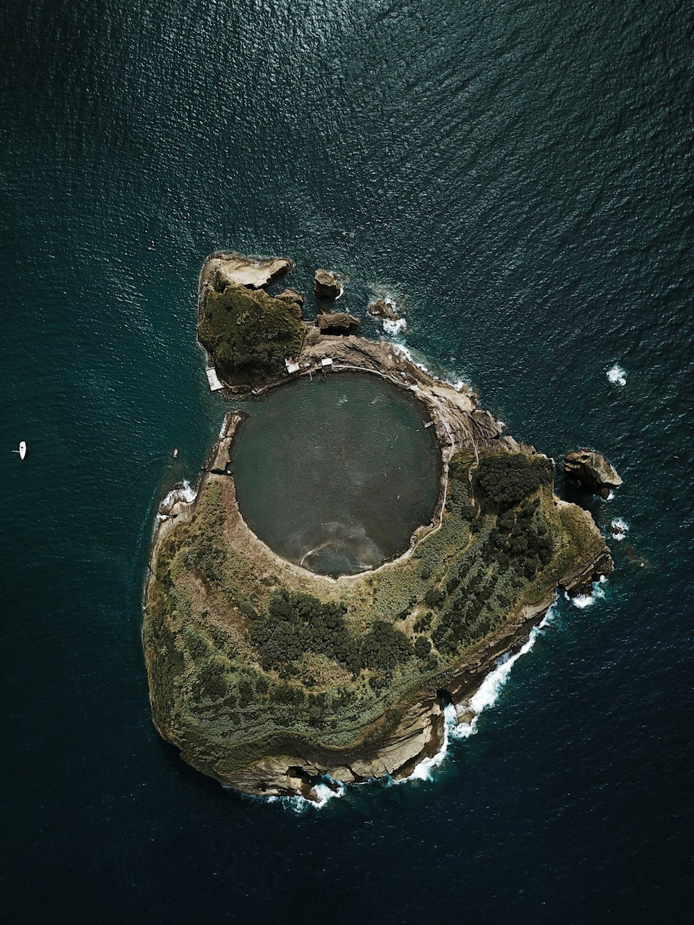 top view photography of island covered with trees surrounded by body of water during daytime