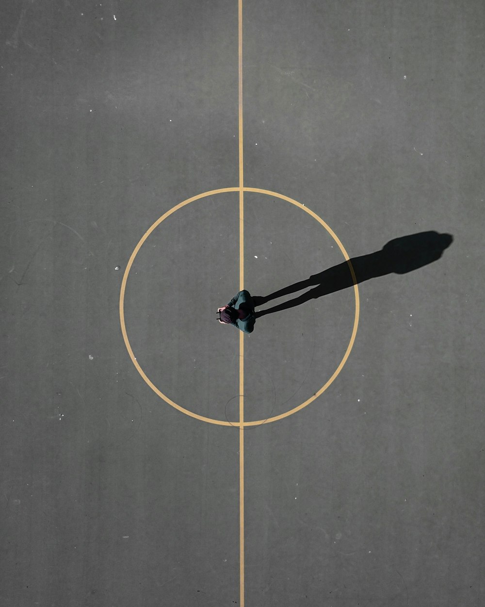 homem manchando no chão de concreto preto projetando sombra
