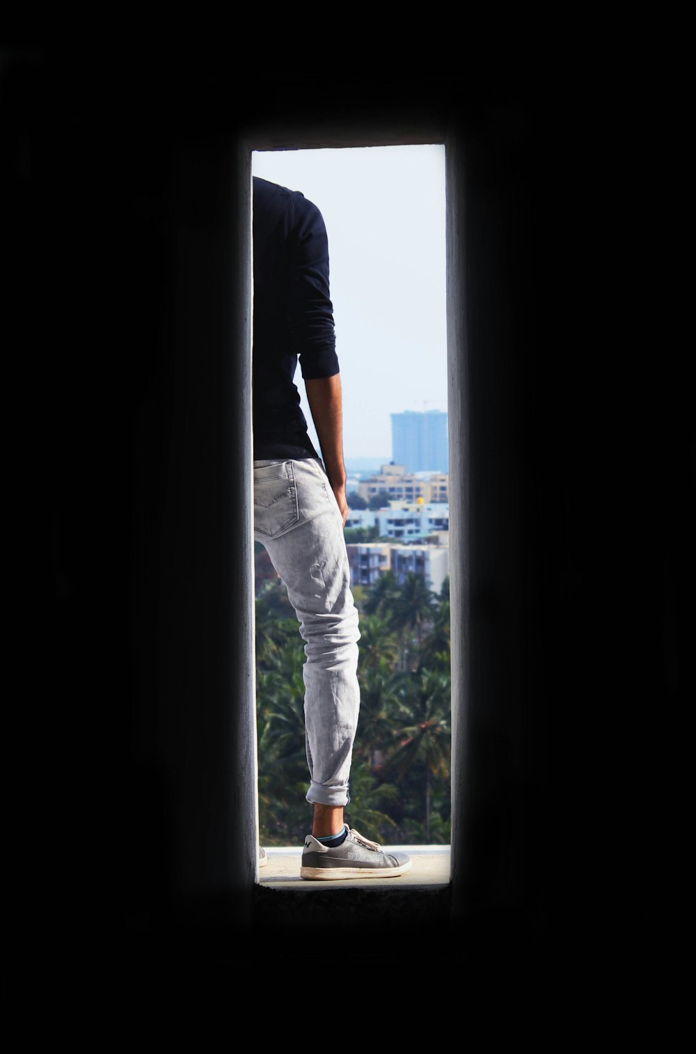 low-light photo of person standing on window