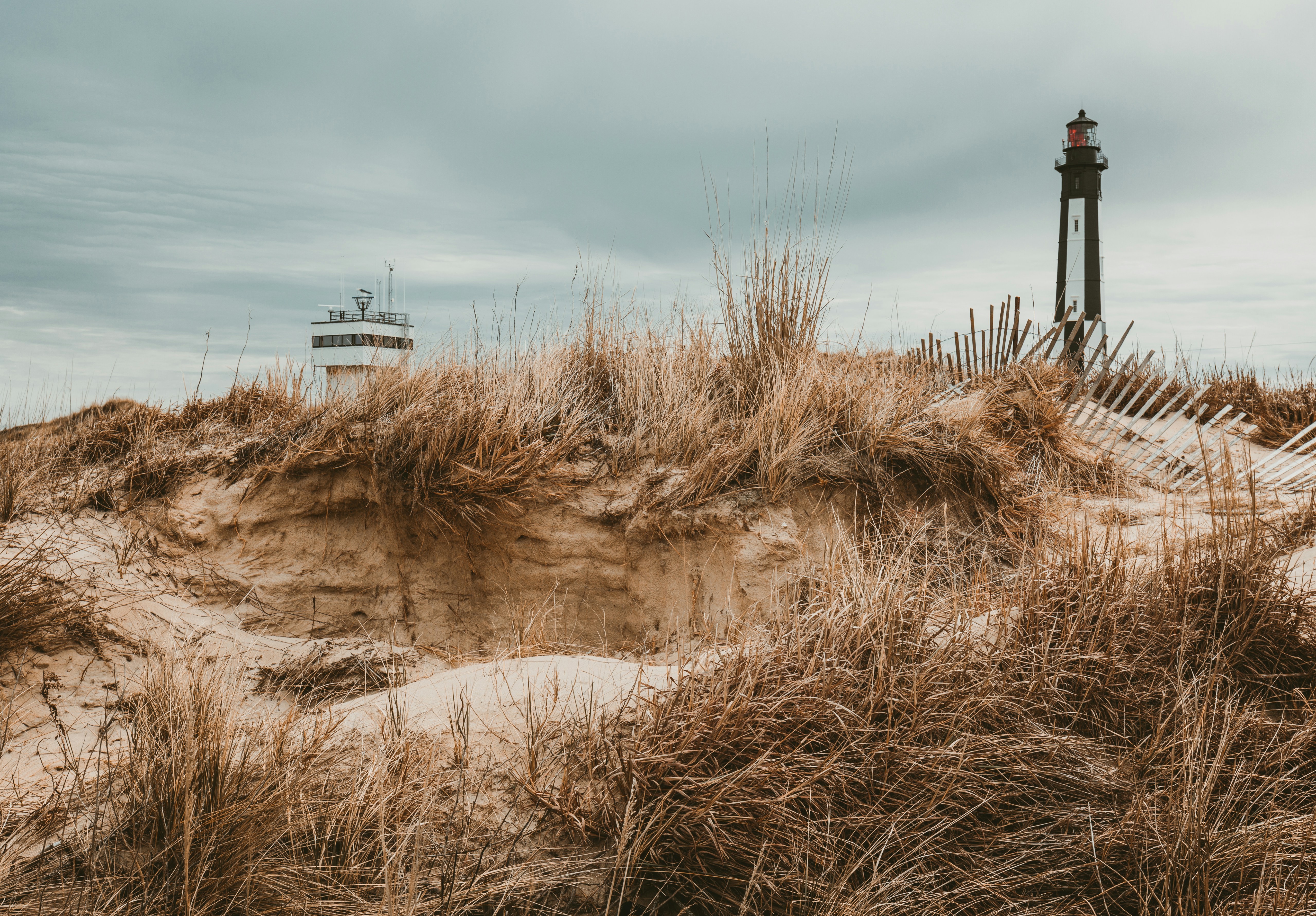 lighthouse near white building during daytime