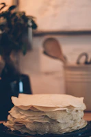 Close-up of freshly made plenty tortillas stacked neatly on a rustic wooden board.