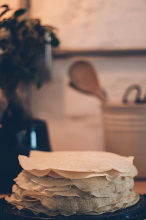 Close-up of freshly made plenty tortillas stacked neatly on a rustic wooden board.