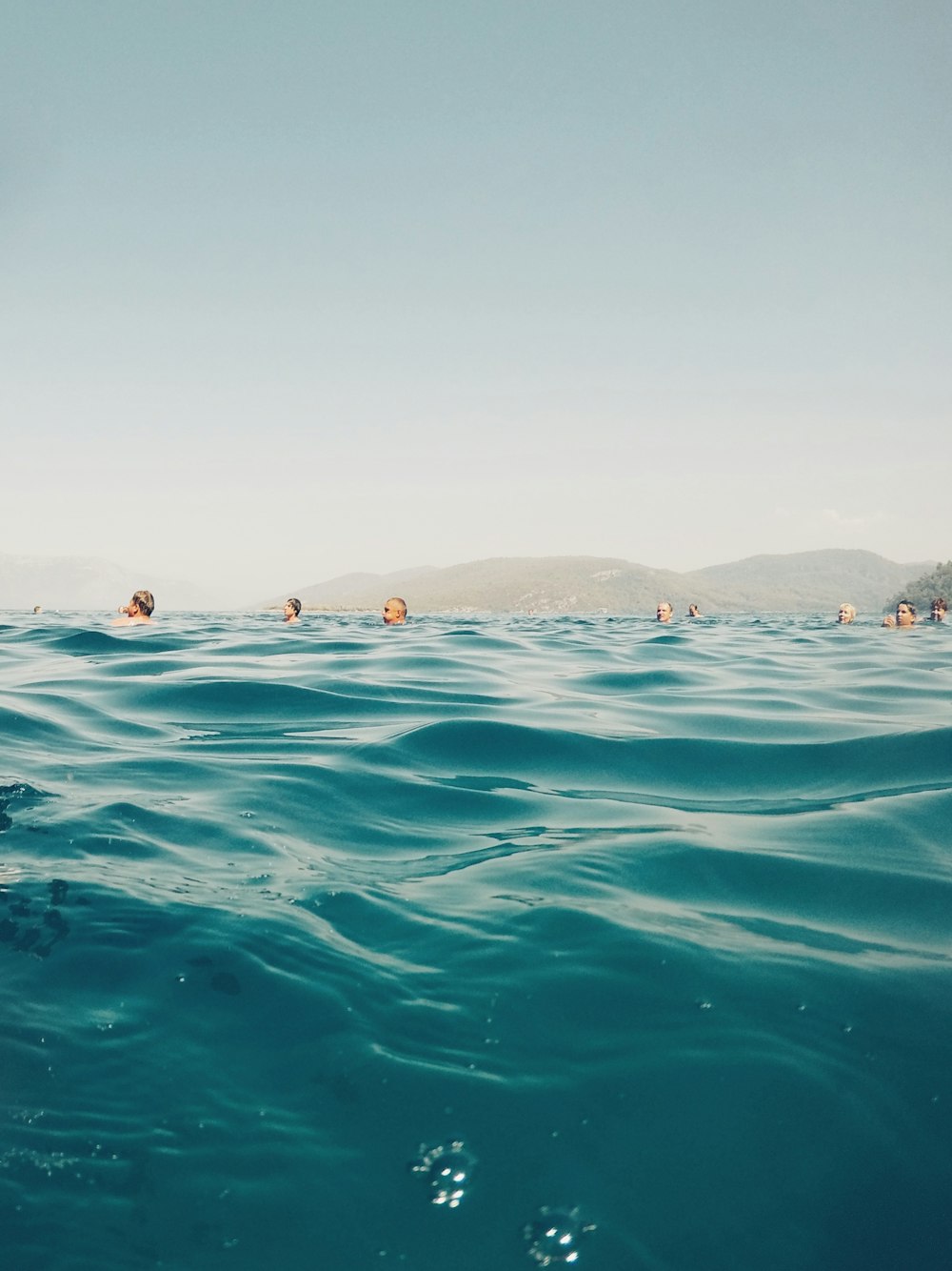 group of people swimming on beach