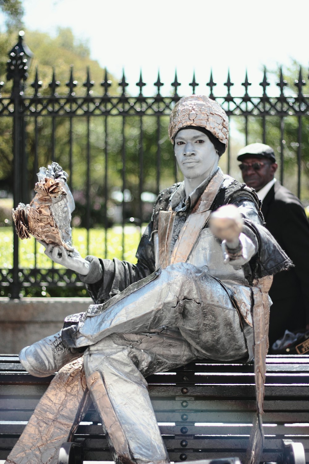 man in white suit sitting on bench