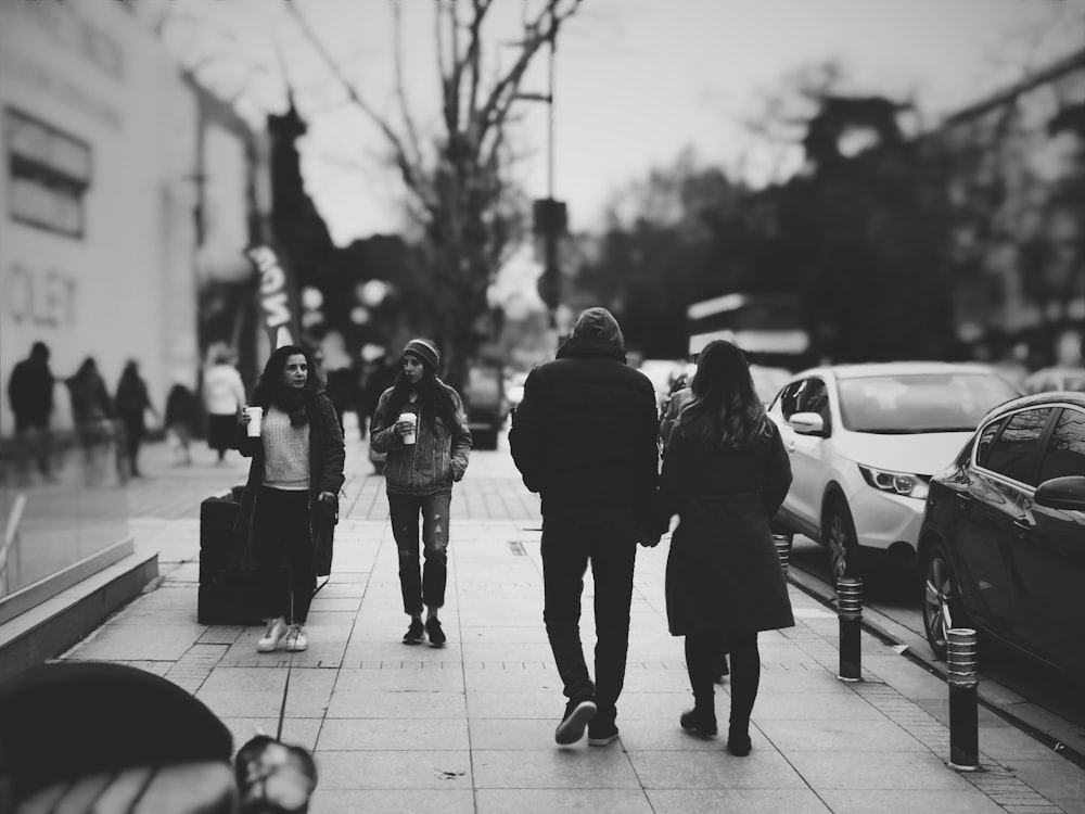 grayscale selective focus photography of people walking on road