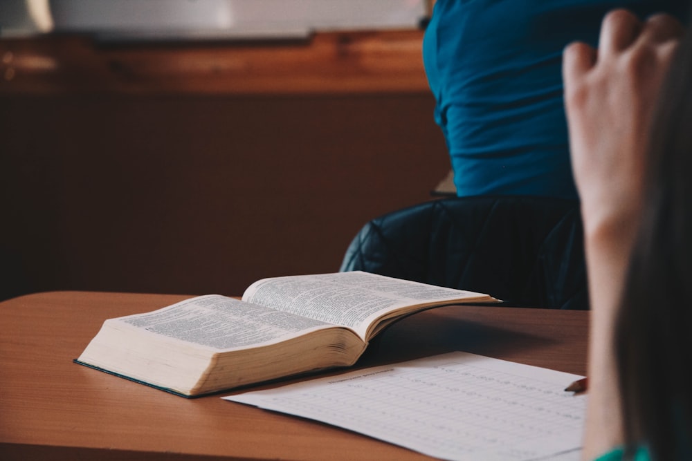 opened book on top of brown desk