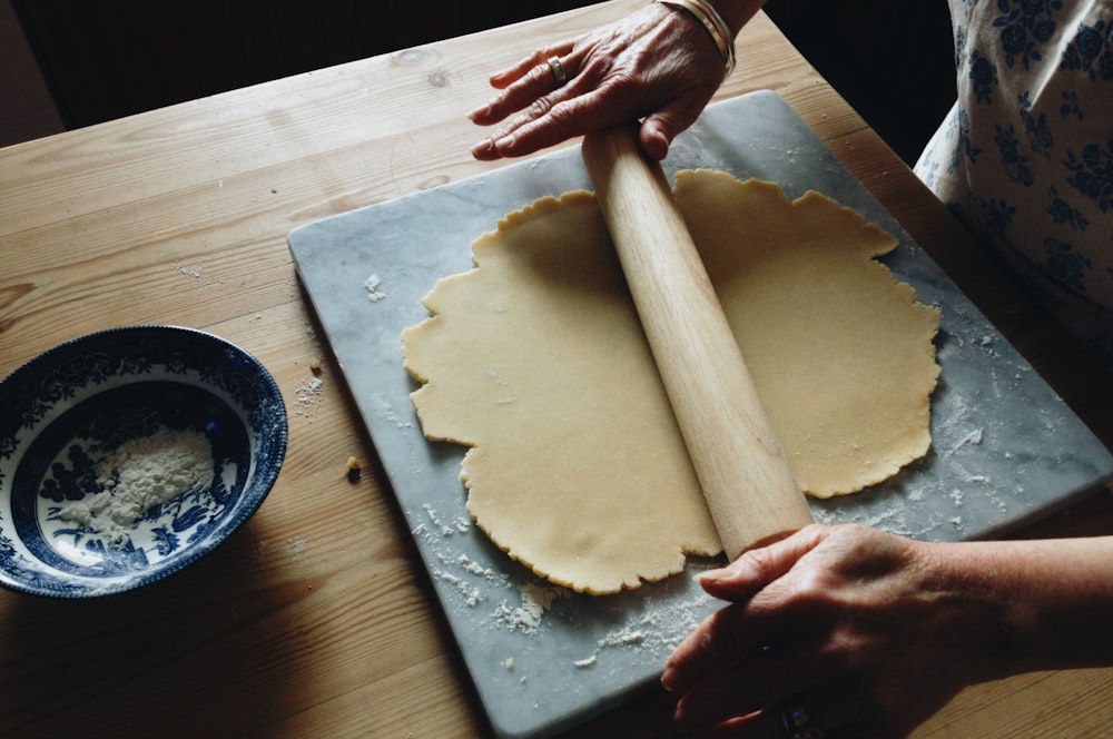 man holding brown rolling pin