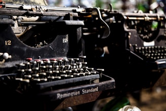 A technician carefully repairing a vintage typewriter in a workshop.