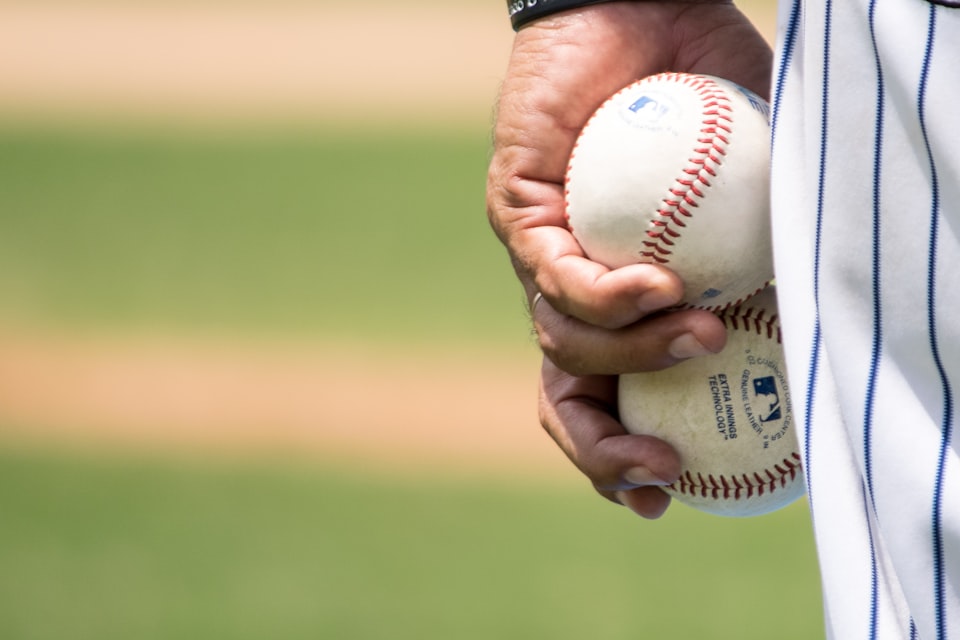 left-hand holding two baseballs