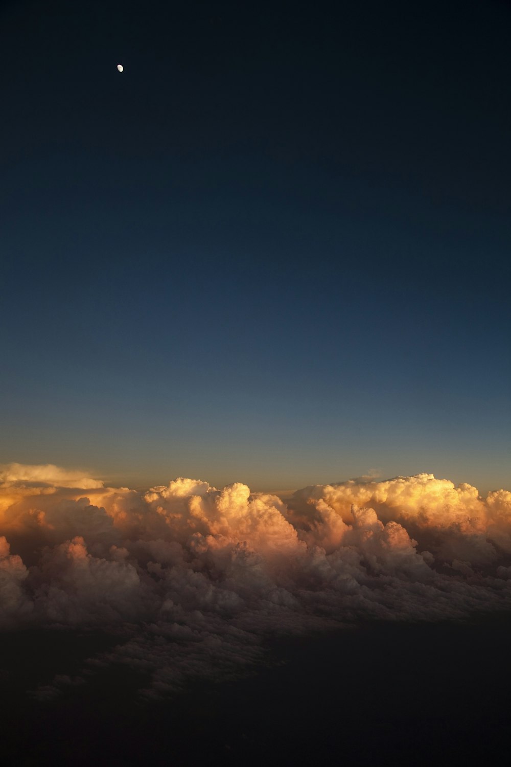 above-cloud photo of a crescent moon