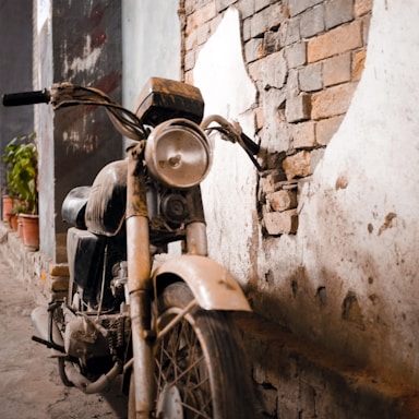 A vintage motorcycle parked beside a classic film camera on a rustic wooden floor.