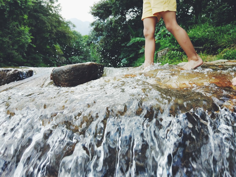 photography of person walking on riverbed