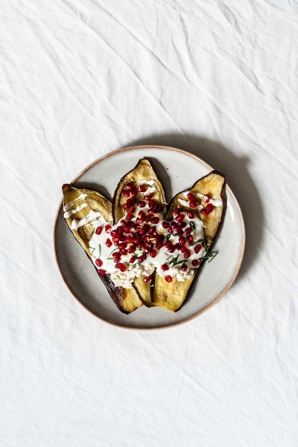 white plate with cream on top of nuts