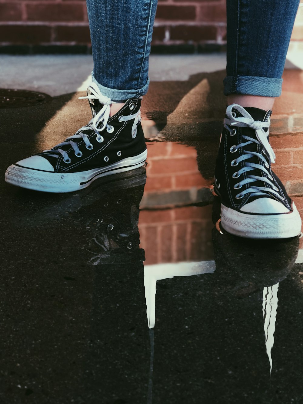 Persona con zapatillas negras de caña alta