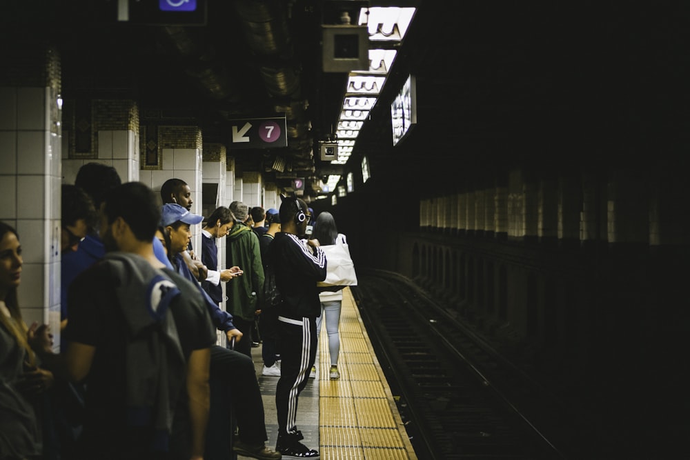 people standing in train station tunnel