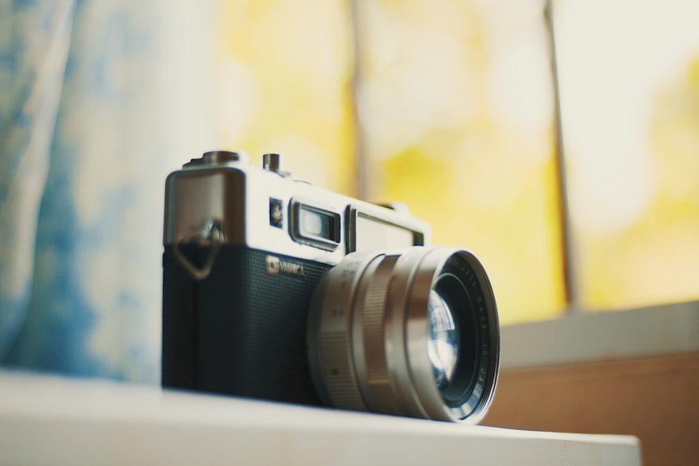 selective focus photography of black and grey DSLR camera on table