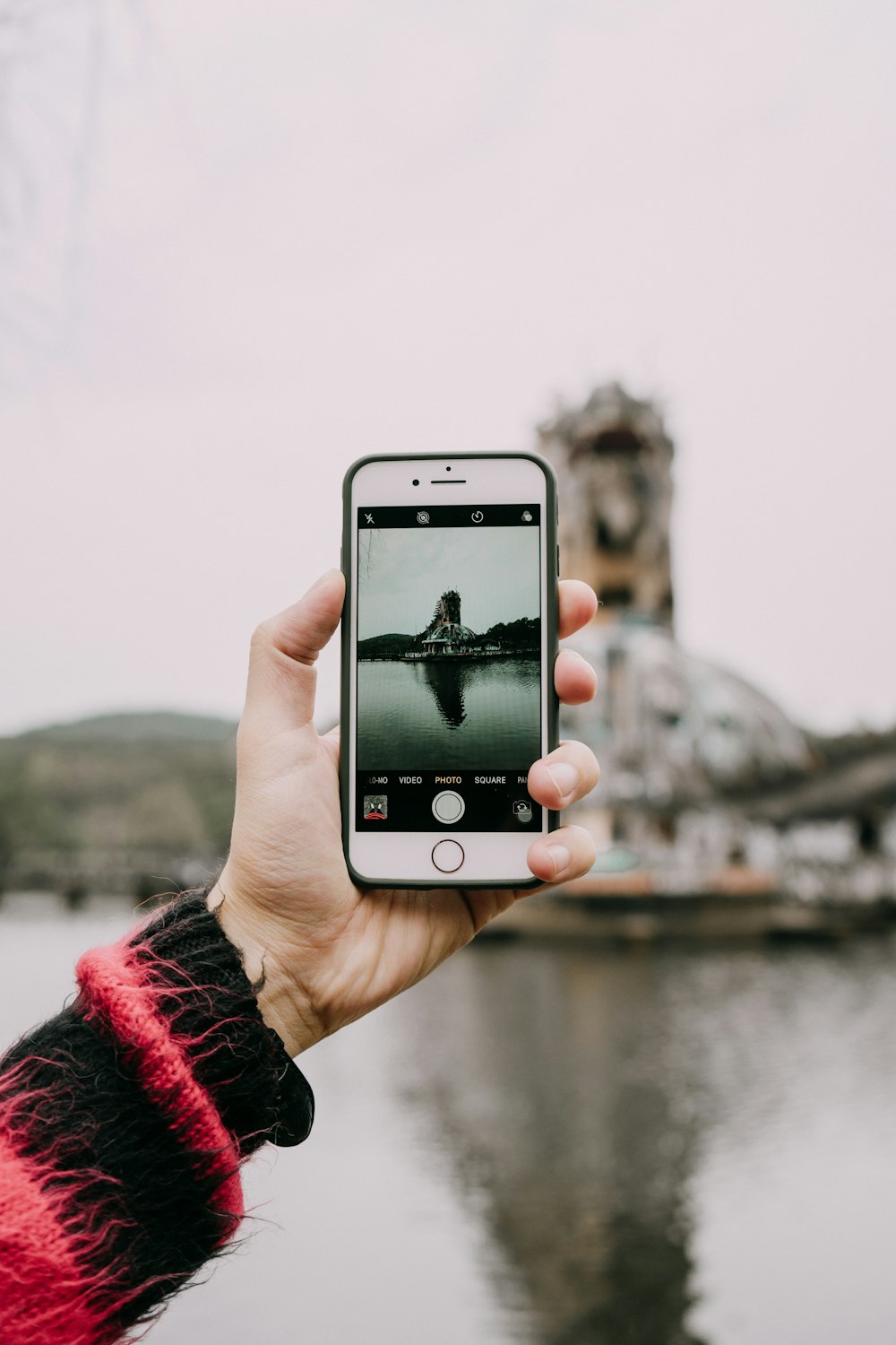 person holding gold iPhone 6 capturing mountain