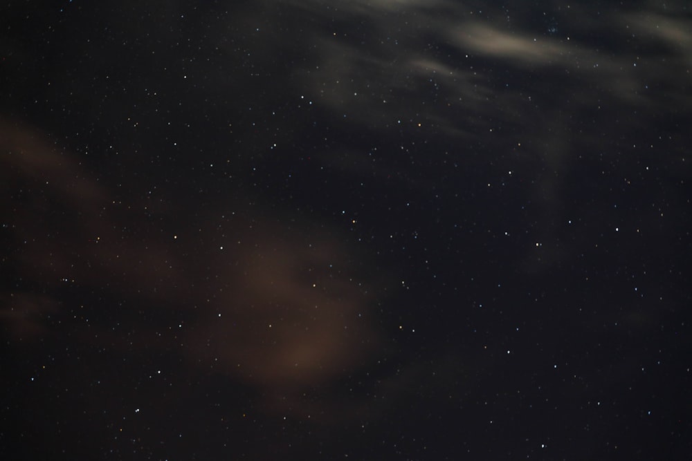 a night sky with stars and a few clouds