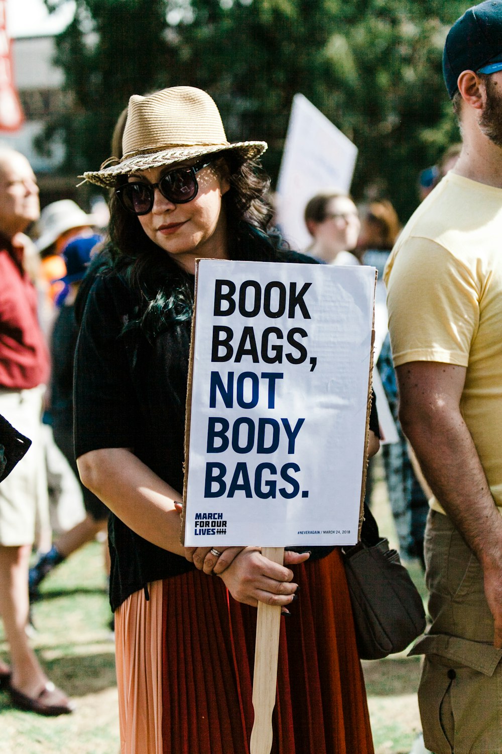 woman holding book bags, not body bags. signboard