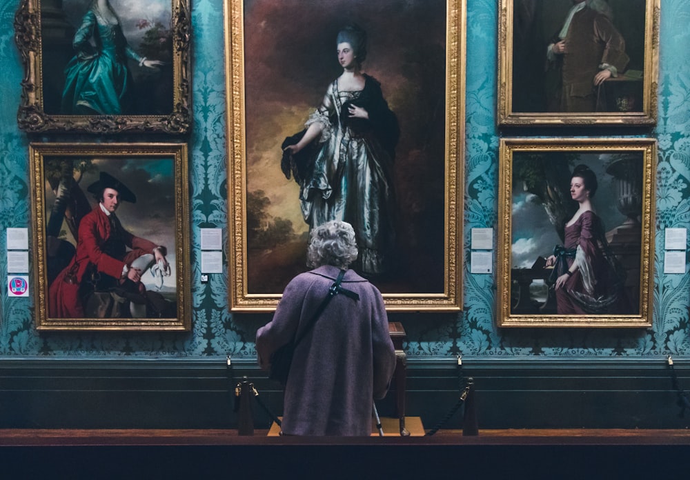 woman looking at painting on wall inside well lit room